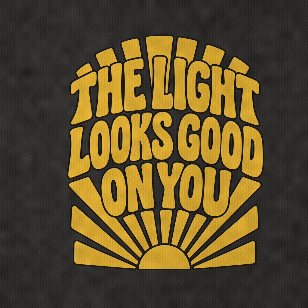 The Light Looks Good On You Sunburst Sayings Vintage T-shirt – black, print and cotton detail (AI mockup)