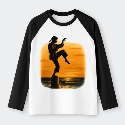 karate crane kick pose on wooden post at beach sunset - Raglan Long Sleeve T-Shirt - Black
