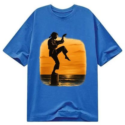 karate crane kick pose on wooden post at beach sunset - Classic T-shirt - Blue