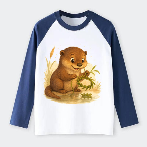 Otter weaving river reeds into a floating crown beside mirror-still - Raglan Long Sleeve T-Shirt