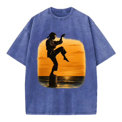 karate crane kick pose on wooden post at beach sunset - Vintage T-shirt - Blue