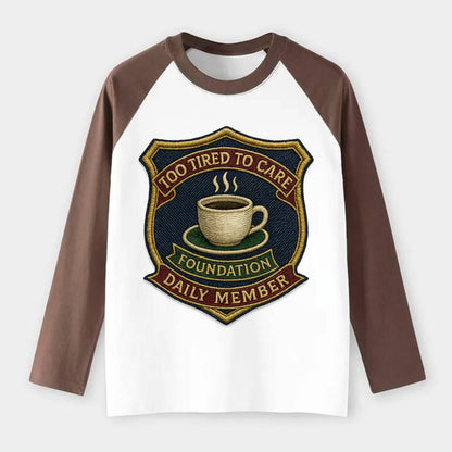 Crest with coffee cup - "Too Tired To Care Foundation - Daily Member" - Raglan Long Sleeve T-Shirt - Coffee
