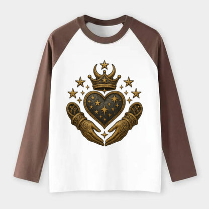 Weathered antique brass crown above a hammered gunmetal heart framed - Raglan Long Sleeve T-Shirt - Coffee
