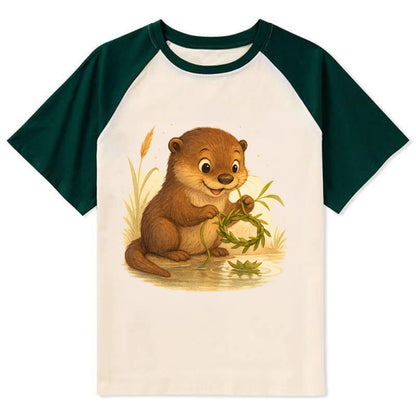 Otter weaving river reeds into a floating crown beside mirror-still water - Contrast Raglan T-shirt - Green