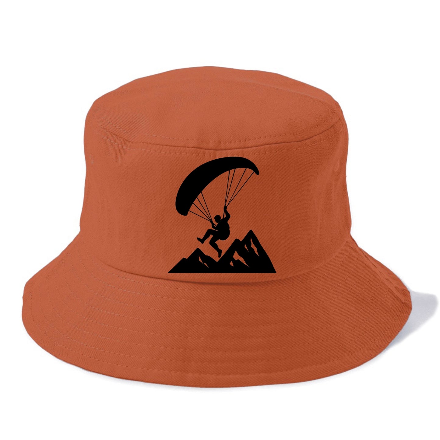 Paraglider soaring over mountain peaks - Bucket Hat - Red