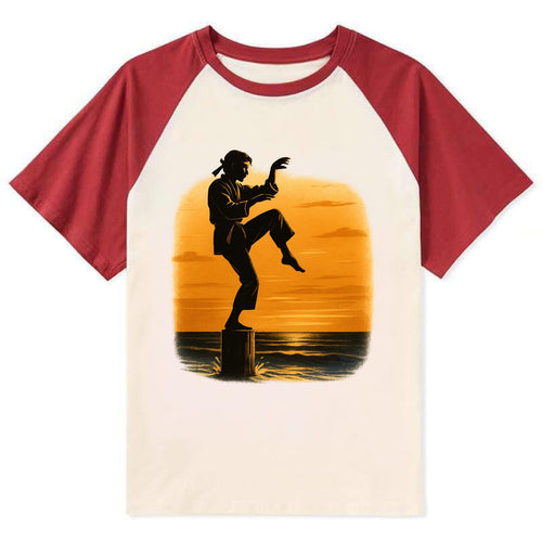 karate crane kick pose on wooden post at beach sunset - Contrast Raglan T-shirt