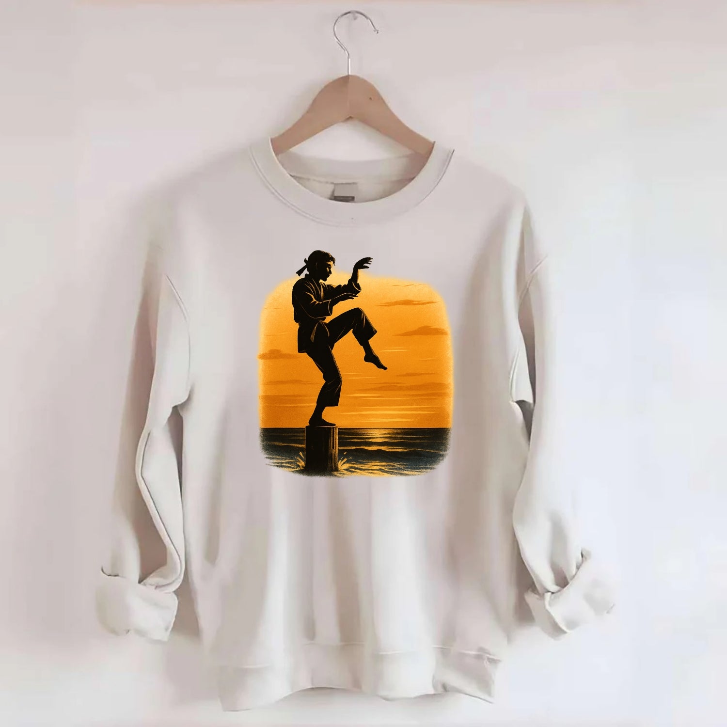 karate crane kick pose on wooden post at beach sunset - Crewneck Sweatshirt - biege