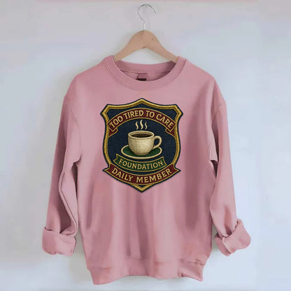 Crest with coffee cup - "Too Tired To Care Foundation - Daily Member" - - Crewneck Sweatshirt - pink